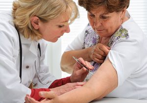 Zeckenbiss behandlung bei einer Frau am Arm